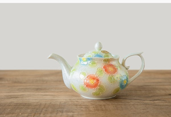Teapot with floral design on a wooden surface