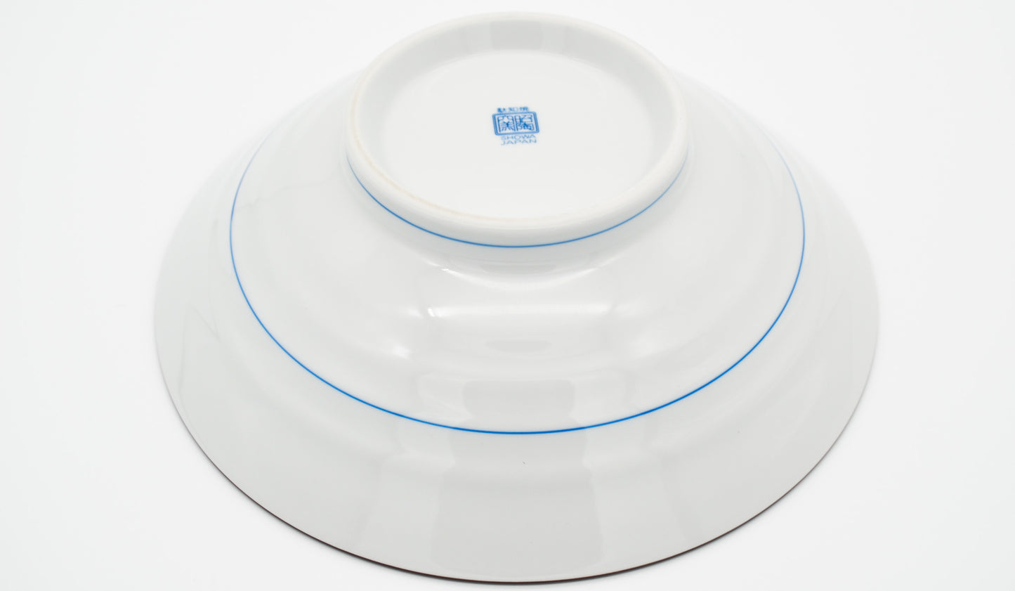 White ceramic dish with blue rim and logo on a white background