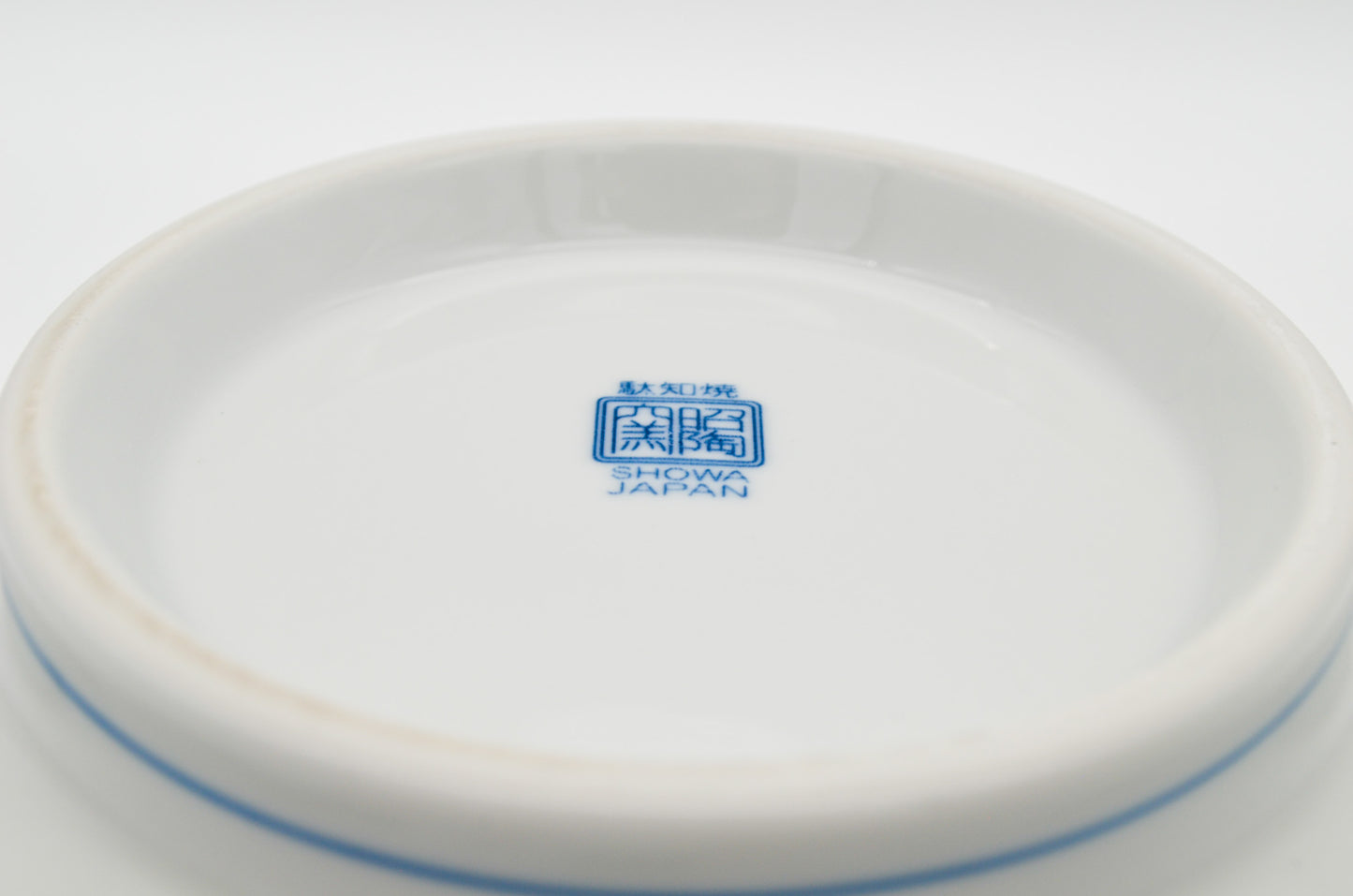 White ceramic plate with blue 'Showa' logo on a white background