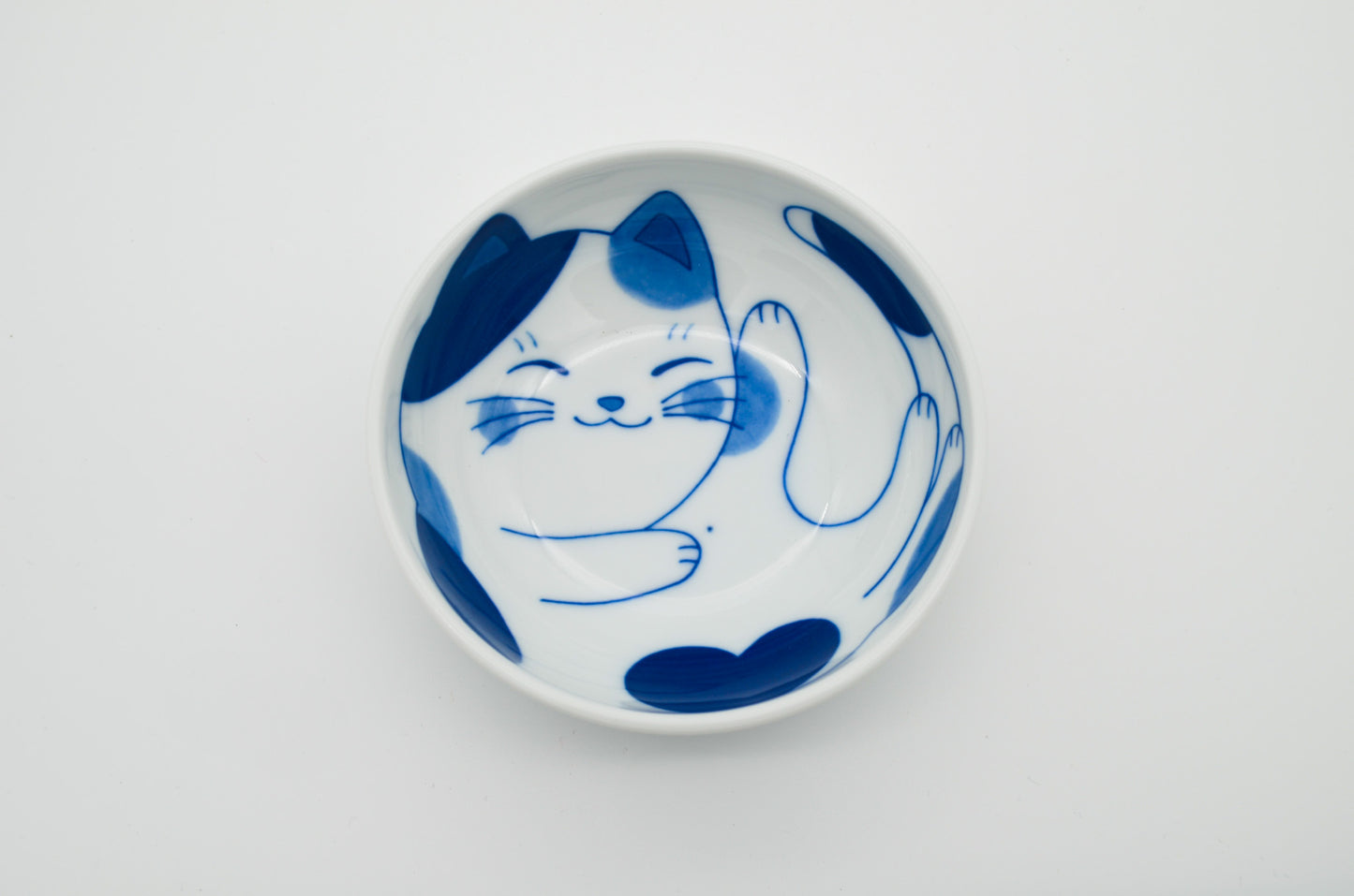 Ceramic plate with blue cat design on a white background