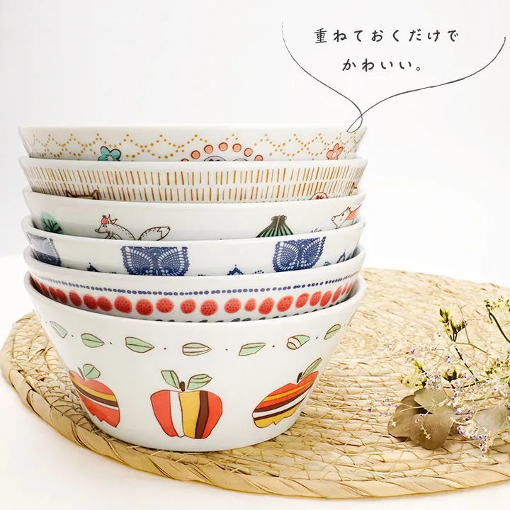 Stack of ceramic bowls with various patterns on a woven mat