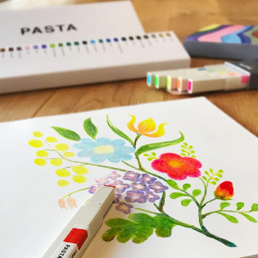 Color swatch book, markers, and a floral drawing on a wooden surface