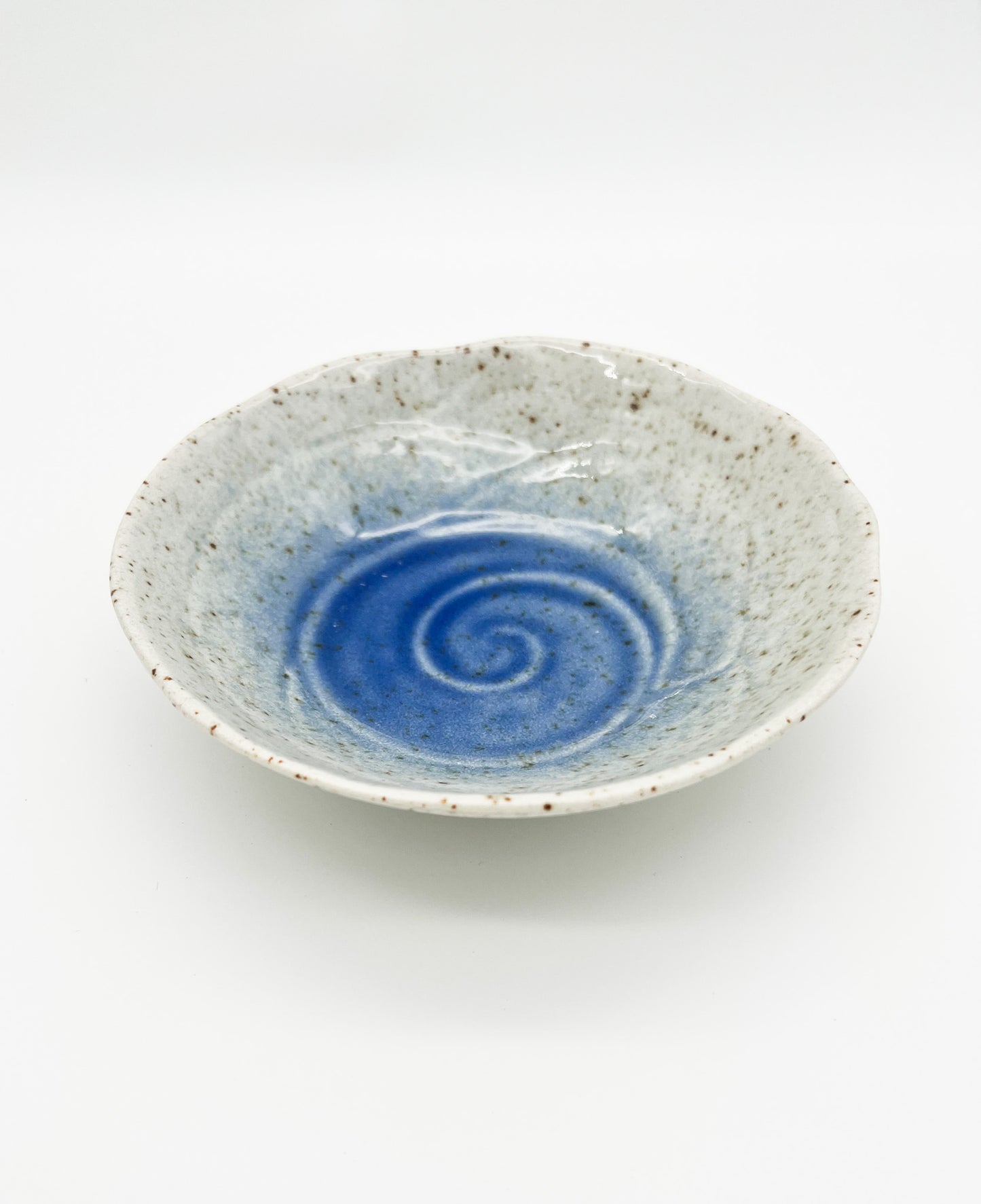Ceramic bowl with blue spiral design on a white background
