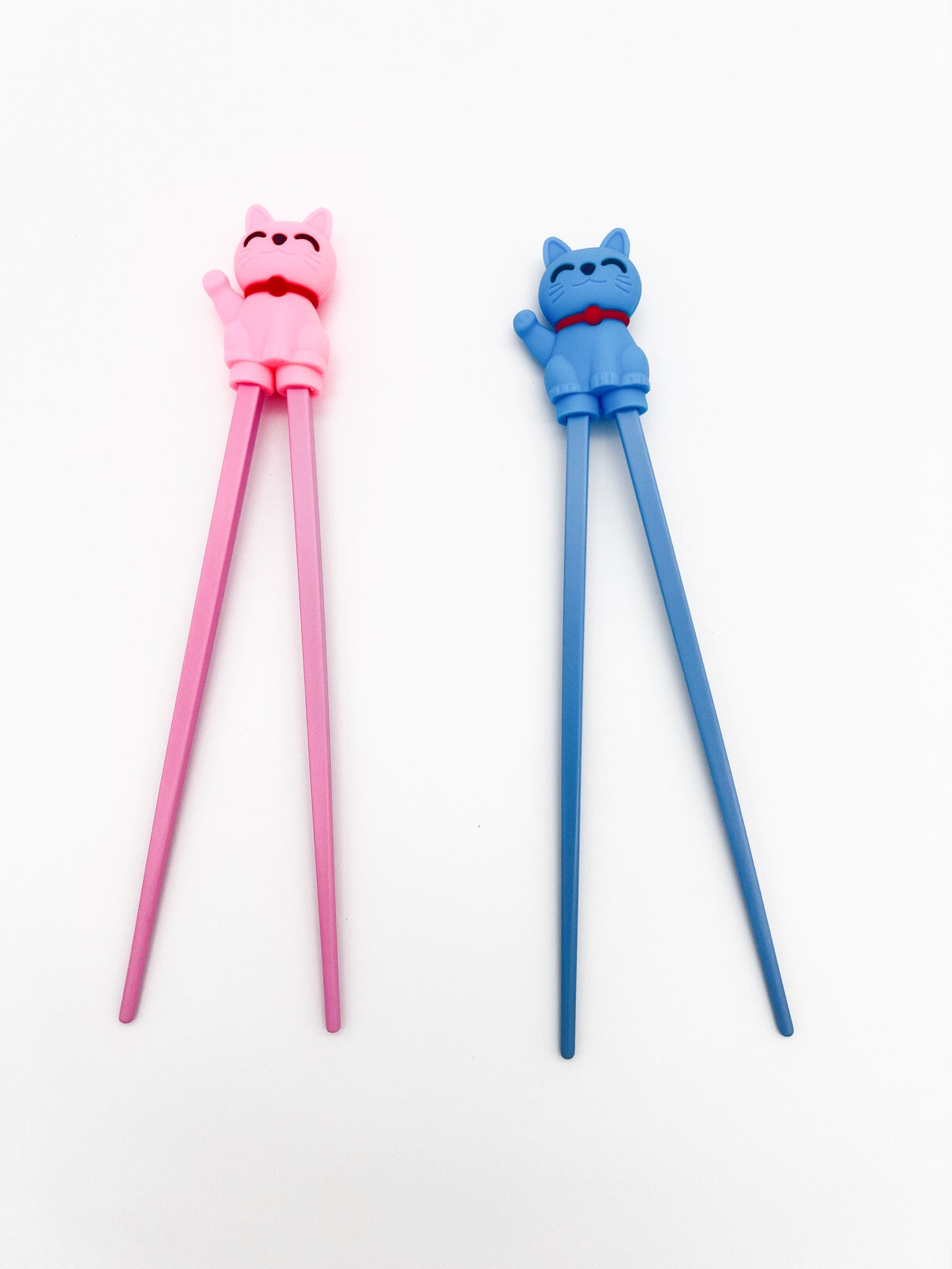 Pink and blue cat-shaped chopsticks on a white background