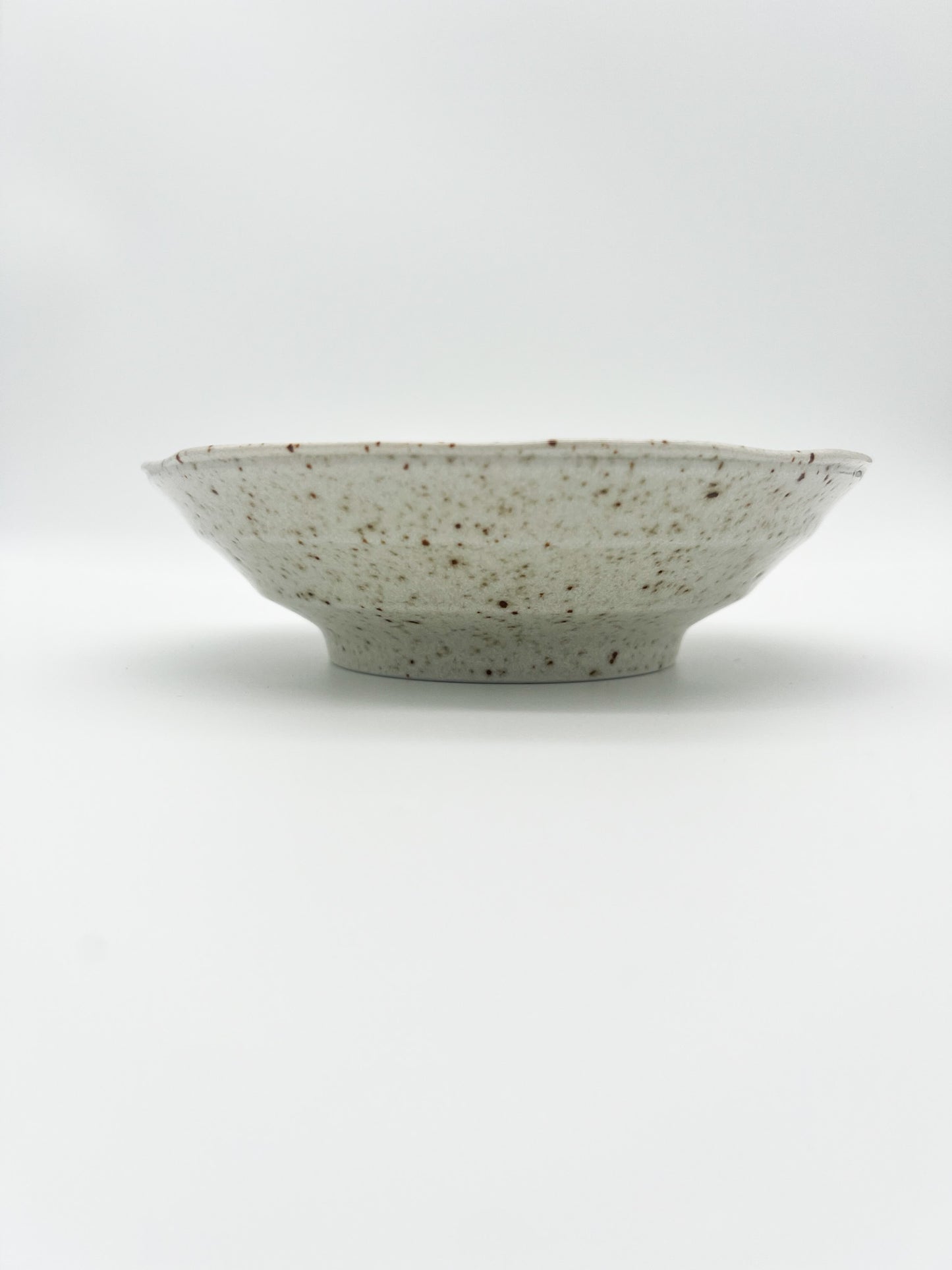 Speckled ceramic bowl on a white background