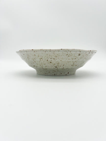 Speckled ceramic bowl on a white background