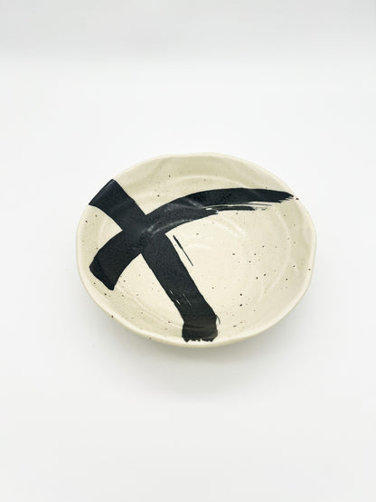 Ceramic plate with black abstract design on a white background