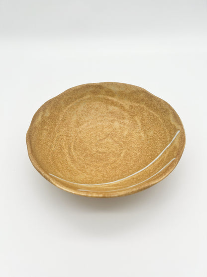 Round ceramic plate with a textured surface on a white background