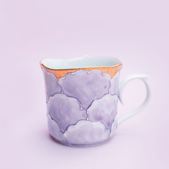 Ceramic mug with cloud design on a light purple background
