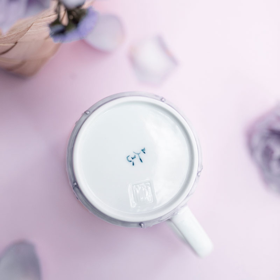 White mug with a lid on a pink surface
