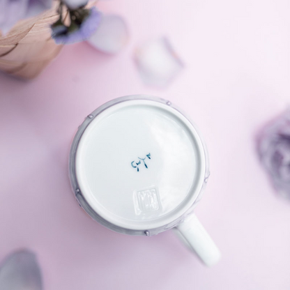 White mug with a lid on a pink surface