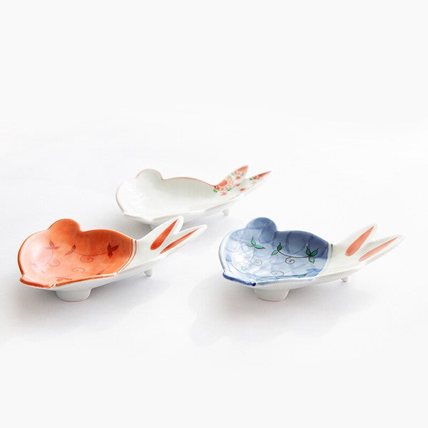 Three ceramic dishes shaped like fish on a white background