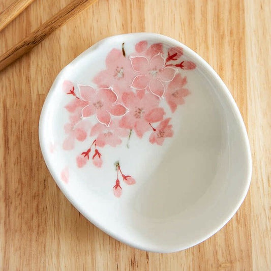 White ceramic dish with pink floral design on a wooden surface
