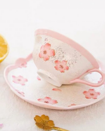Ceramic cup and saucer with pink floral design on a white background