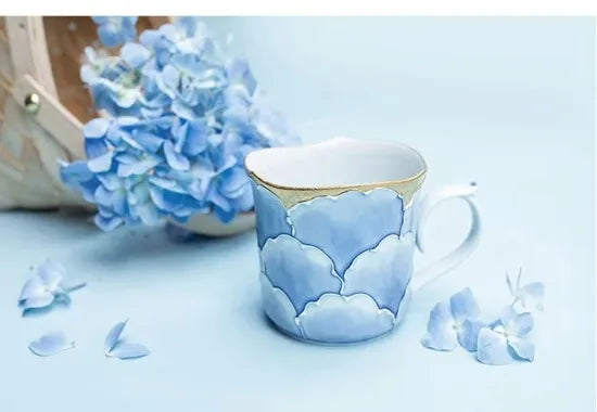 Ceramic mug with cloud design on a light blue background with flowers