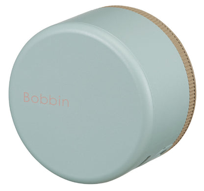 Light blue bobbin with wooden top on a white background