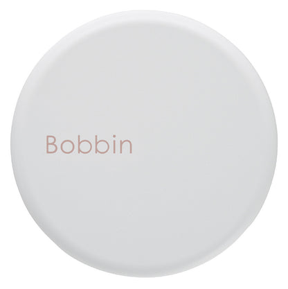 Round white object with 'Bobbin' text on a white background