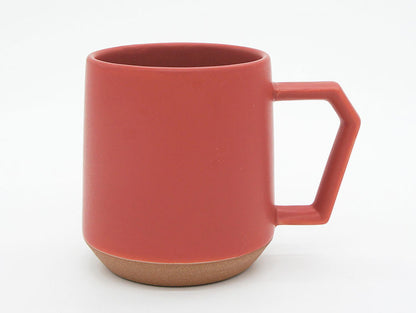 Red ceramic mug with a brown base on a white background