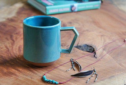 Blue mug on a wooden surface with sunglasses and a necklace. Japanese Ceramic. Made in Japan