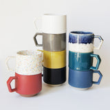 Set of colorful ceramic mugs on a white background