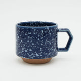 Blue speckled mug with a handle on a white background