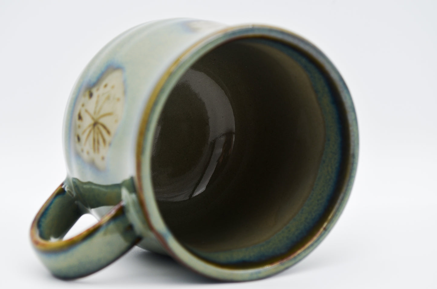 Ceramic mug with a decorative handle on a white background