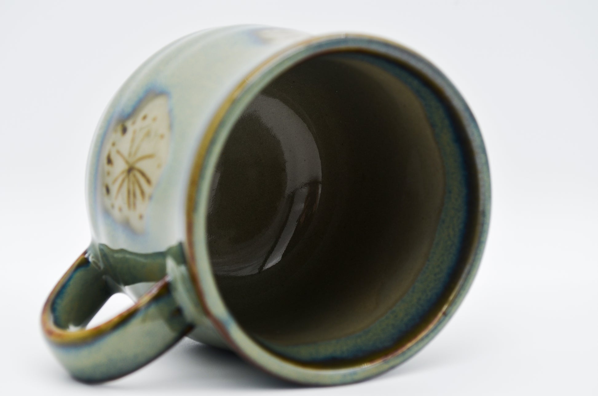 Ceramic mug with a decorative handle on a white background