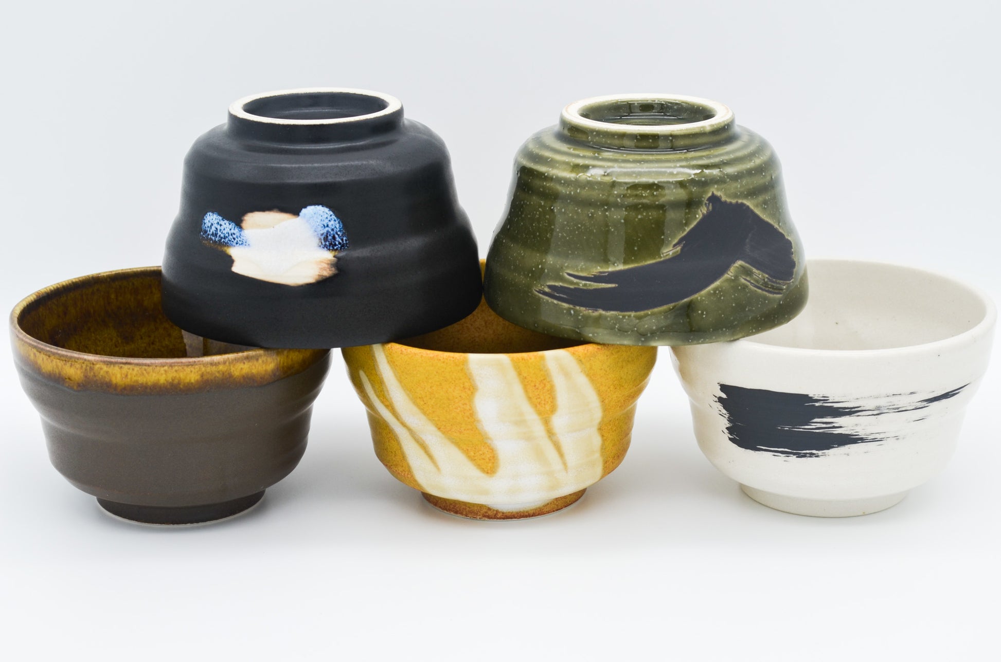 Five ceramic bowls with different designs on a white background