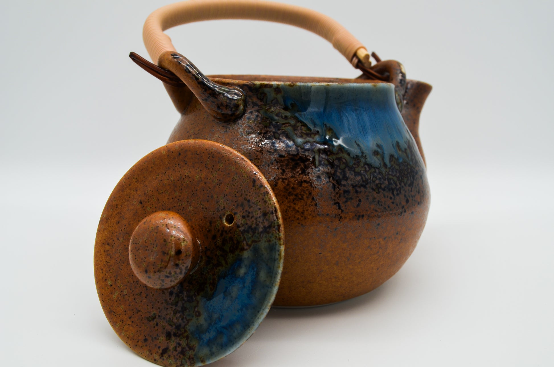 Ceramic teapot with blue glaze on a white background