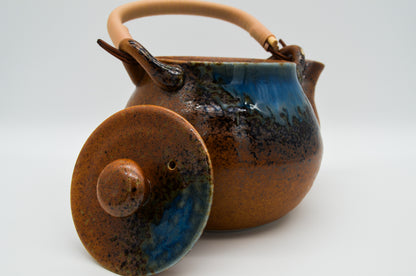 Ceramic teapot with blue glaze on a white background