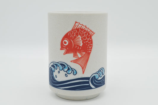 Ceramic tumbler with red fish and blue wave design on a white background