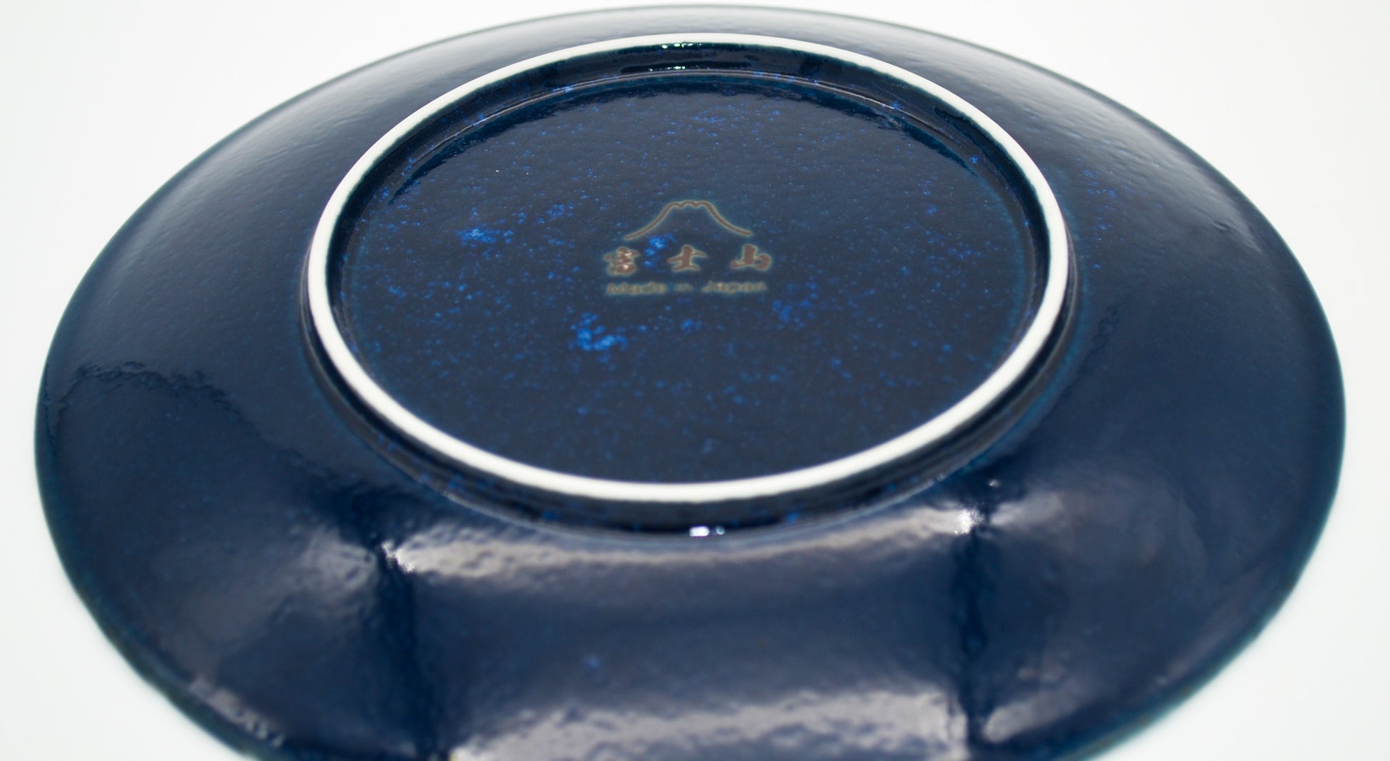 Navy blue ceramic plate with a logo on a white background