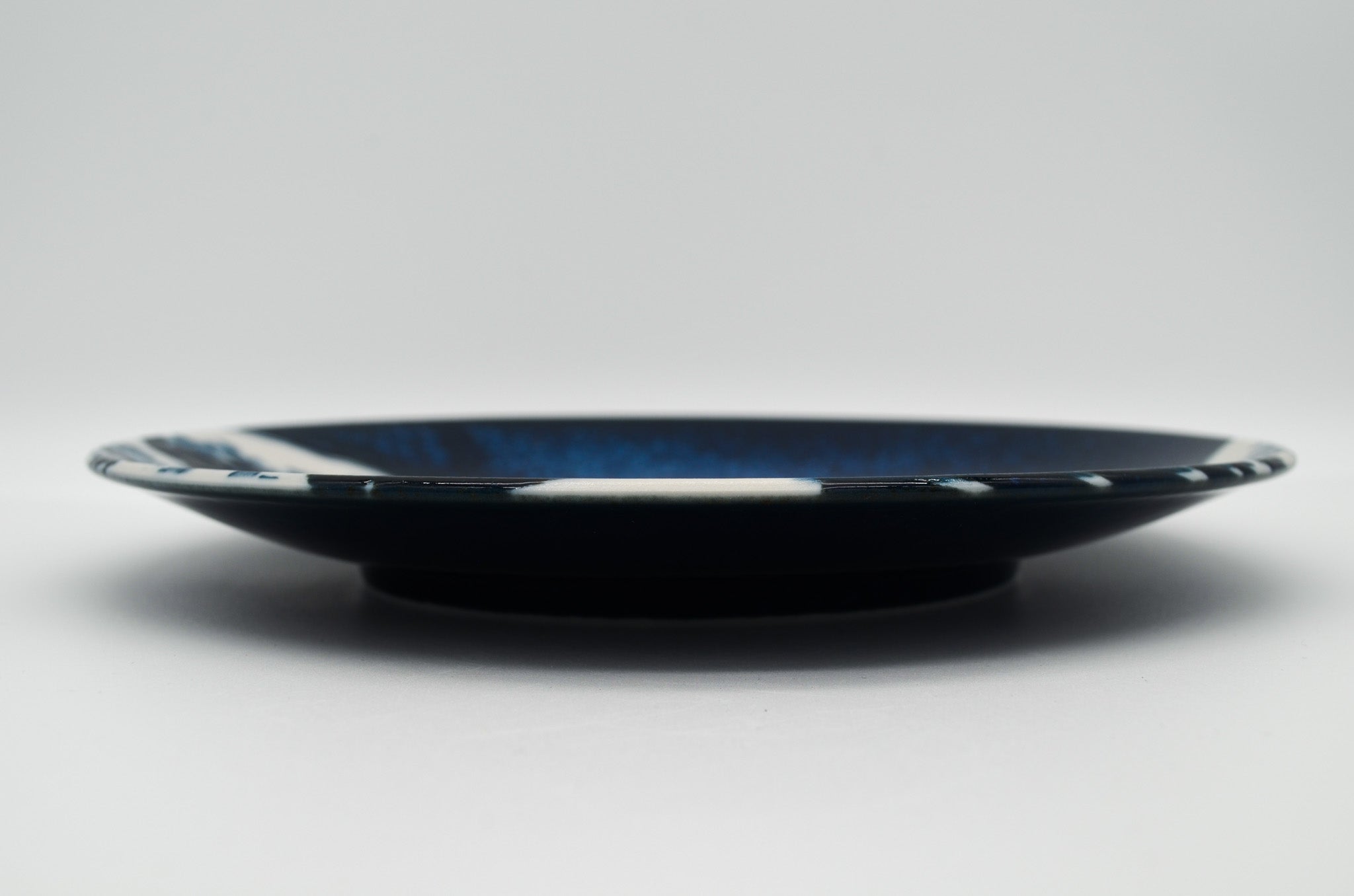 Black plate with blue rim on a white background