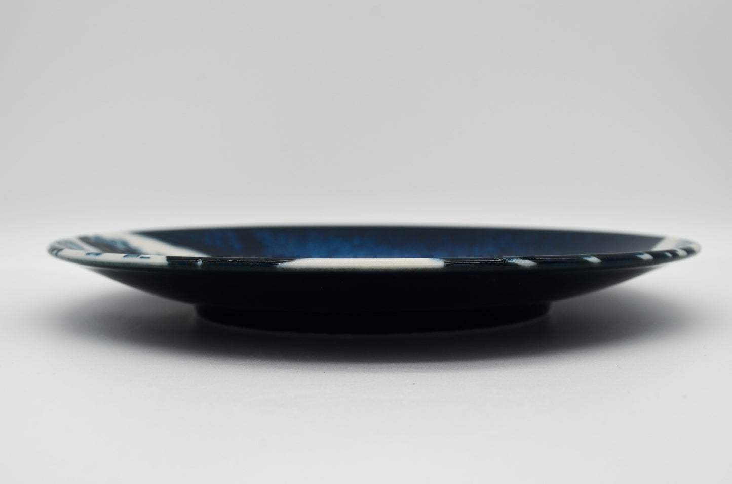 Black plate with blue rim on a white background