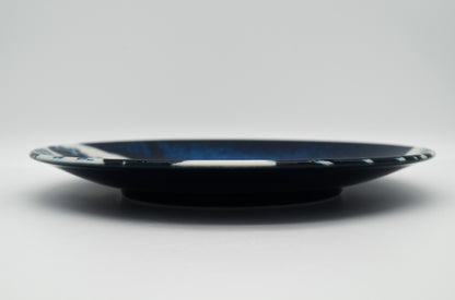 Black plate with blue rim on a white background