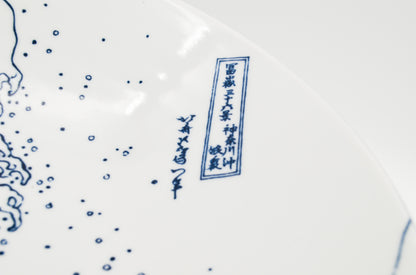 Close-up of a ceramic plate with blue floral patterns and text on a white background