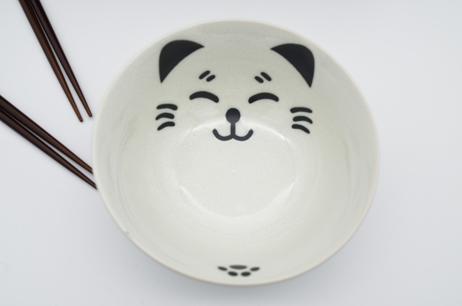 Ceramic bowl with a cat face design on a white background