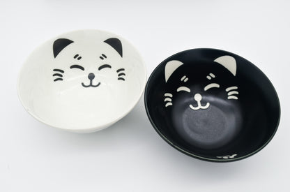Two ceramic bowls with cat face designs on a white background