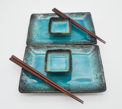 Set of blue ceramic plates with brown chopsticks on a white background