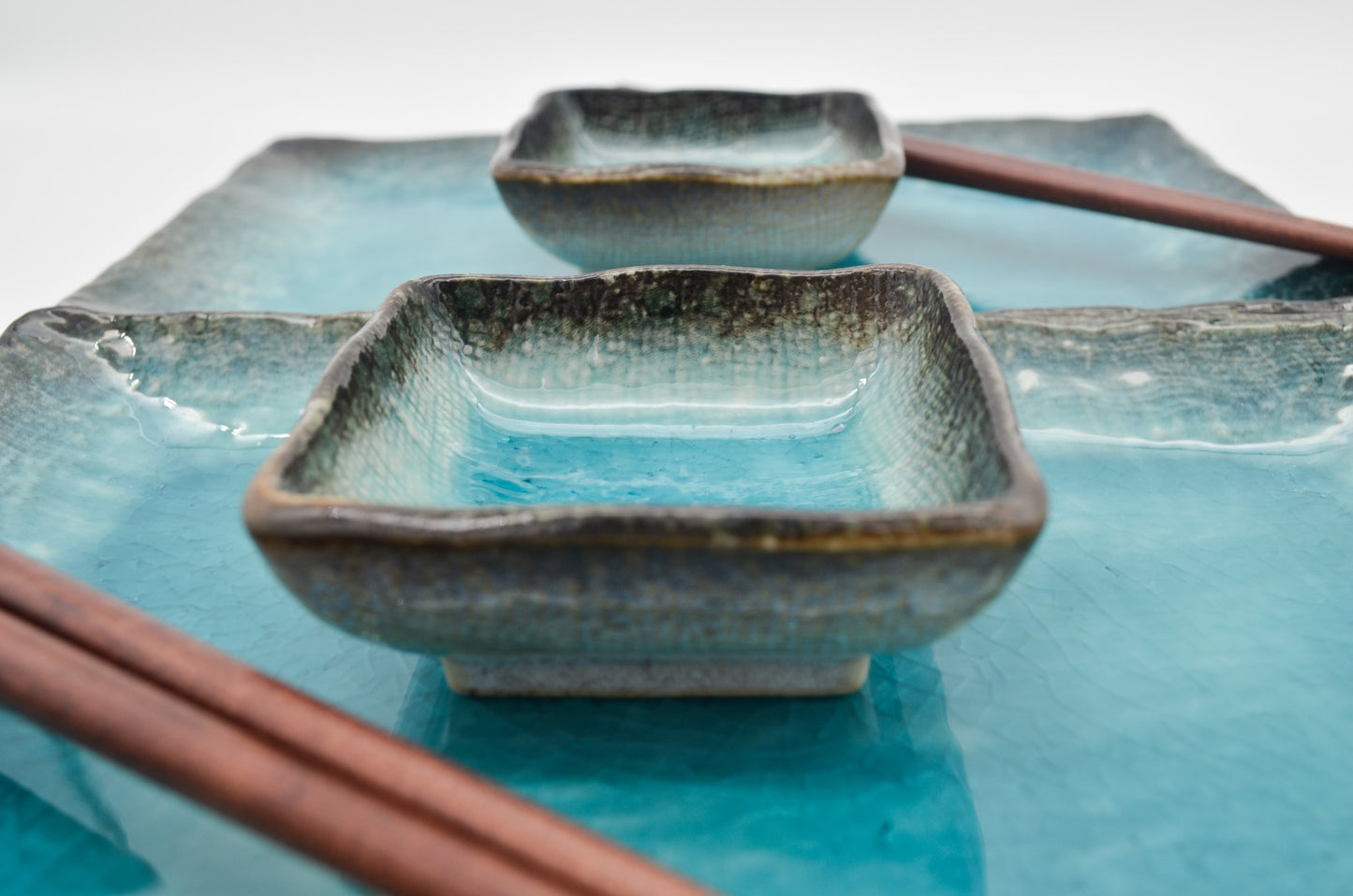 Set of ceramic dishes with a textured finish on a blue background