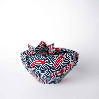 Fabric bowl with red and blue wave pattern on a white background