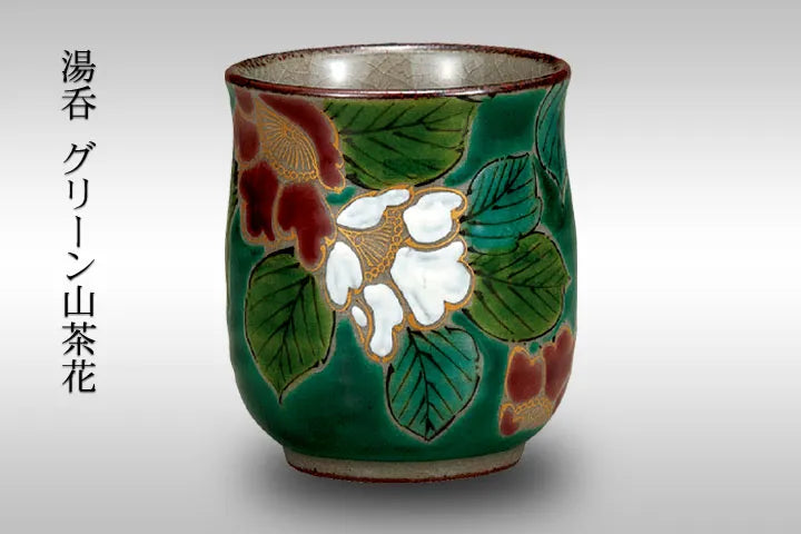 Green ceramic cup with green camellia floral design on a gray background
