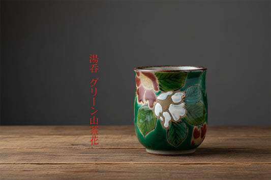 Decorative ceramic cup with floral design on a wooden surface and dark background