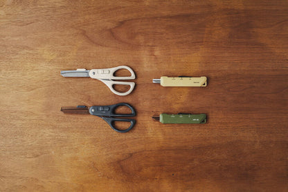 Two pairs of scissors and two pen knives on a wooden surface