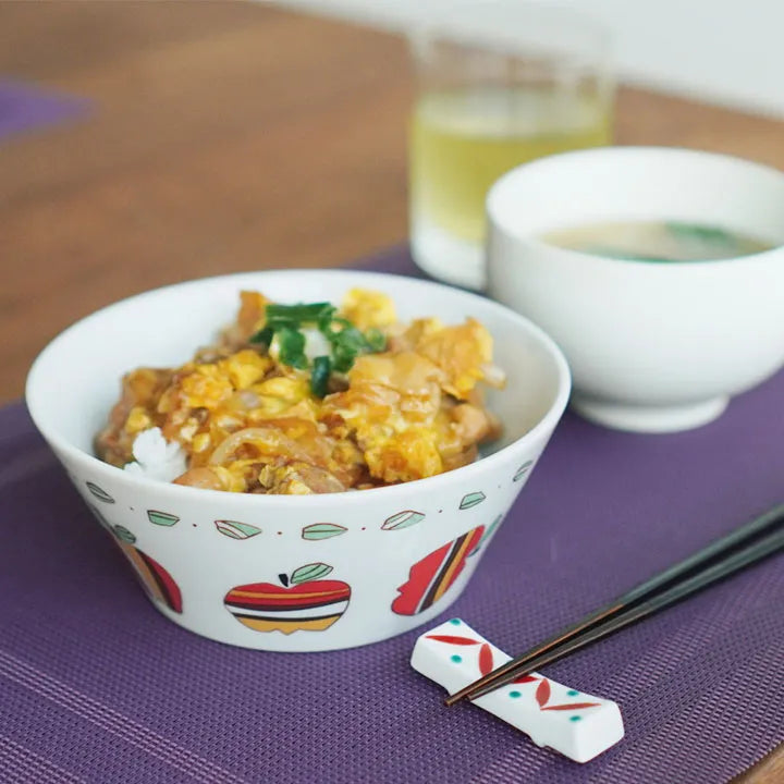 Bowl of food with chopsticks on a purple mat