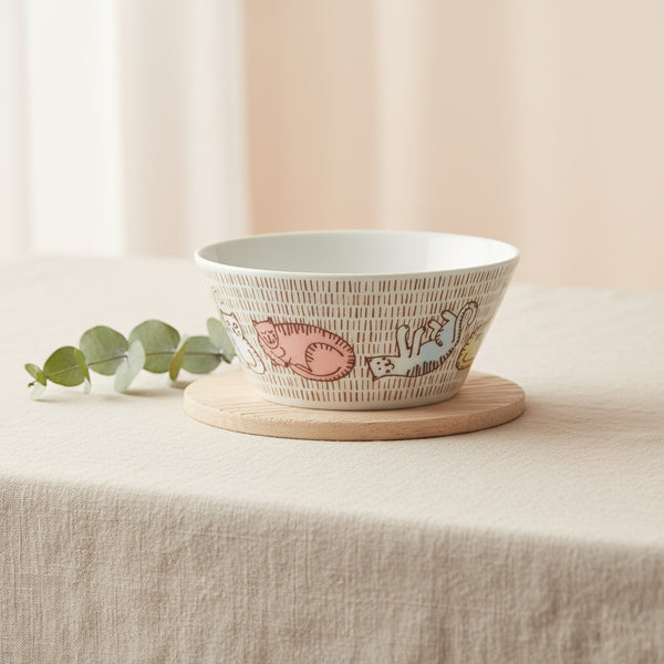 Decorative bowl with animal illustrations on a wooden coaster on a beige surface.