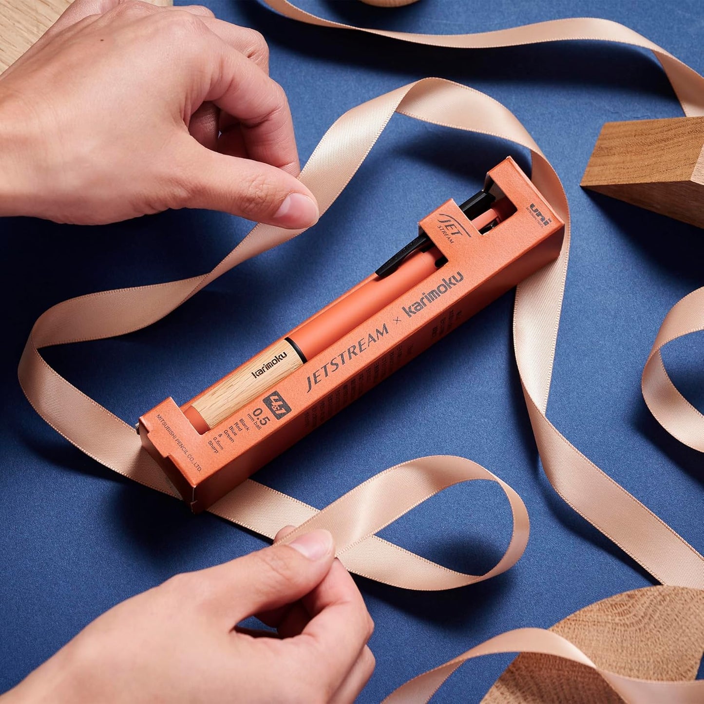 Kuretake Jetstream pen with ribbons on a blue background