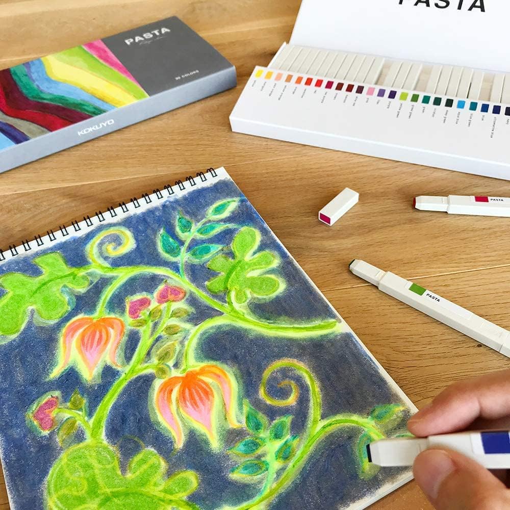 Colorful drawing of plants on a notebook with markers and color chart on a wooden table.