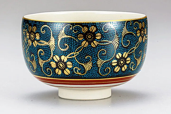 Decorative ceramic bowl with blue and gold floral patterns on a white background