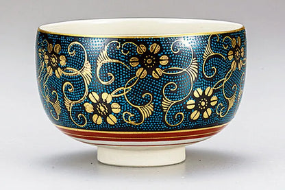 Decorative ceramic bowl with blue and gold floral patterns on a white background
